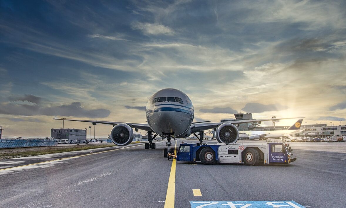 airplane, runway, airport, tarmac, aircraft, vehicle, truck, airliner, clouds, asphalt, jet, flight, transportation system, nature, air travel, outdoor, airline, plane, transportation, travel, airfield